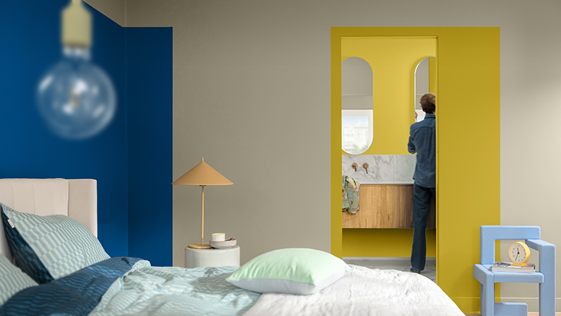 Bedroom with dark blue feature wall and yellow doorway into bathroom